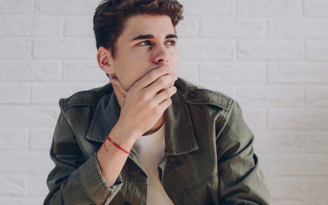 Man covering his mouth and thinking